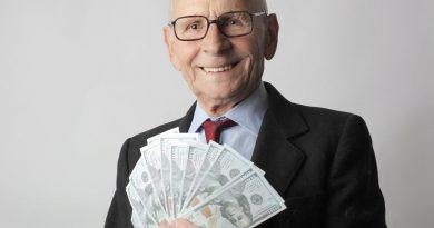 man in black suit holding dollar bills