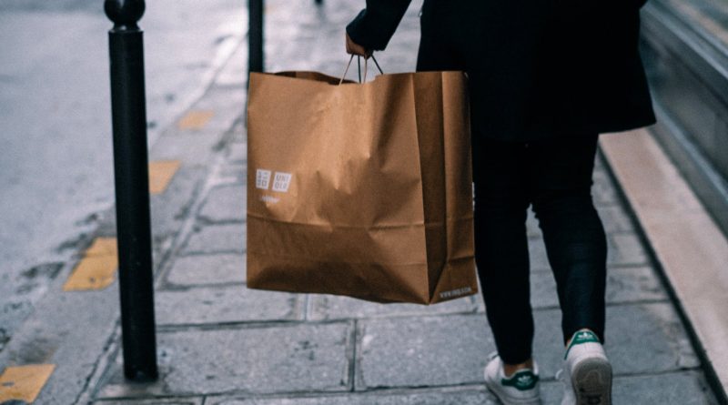 person carrying a uniqlo paper bag