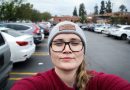 woman taking photo of herself near parked vehicles