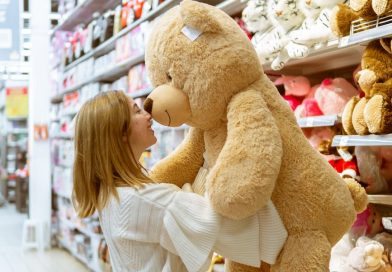 woman carrying bear plush toy inside store